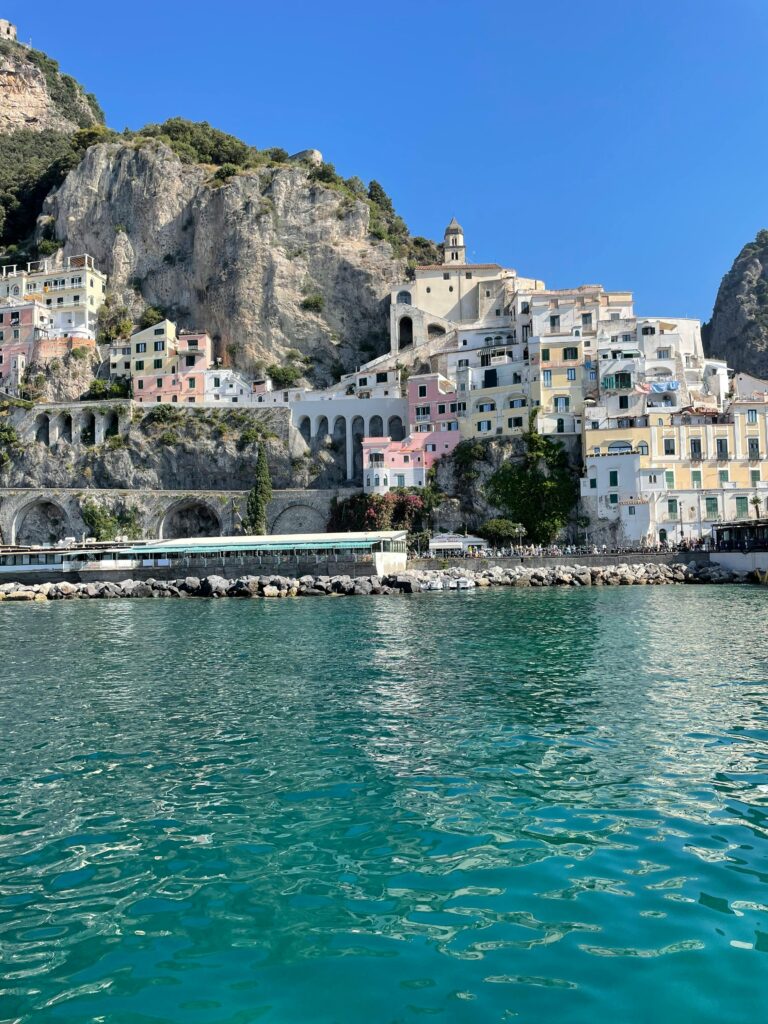 Scenic view of colorful buildings along the Amalfi Coast in Italy with turquoise waters.