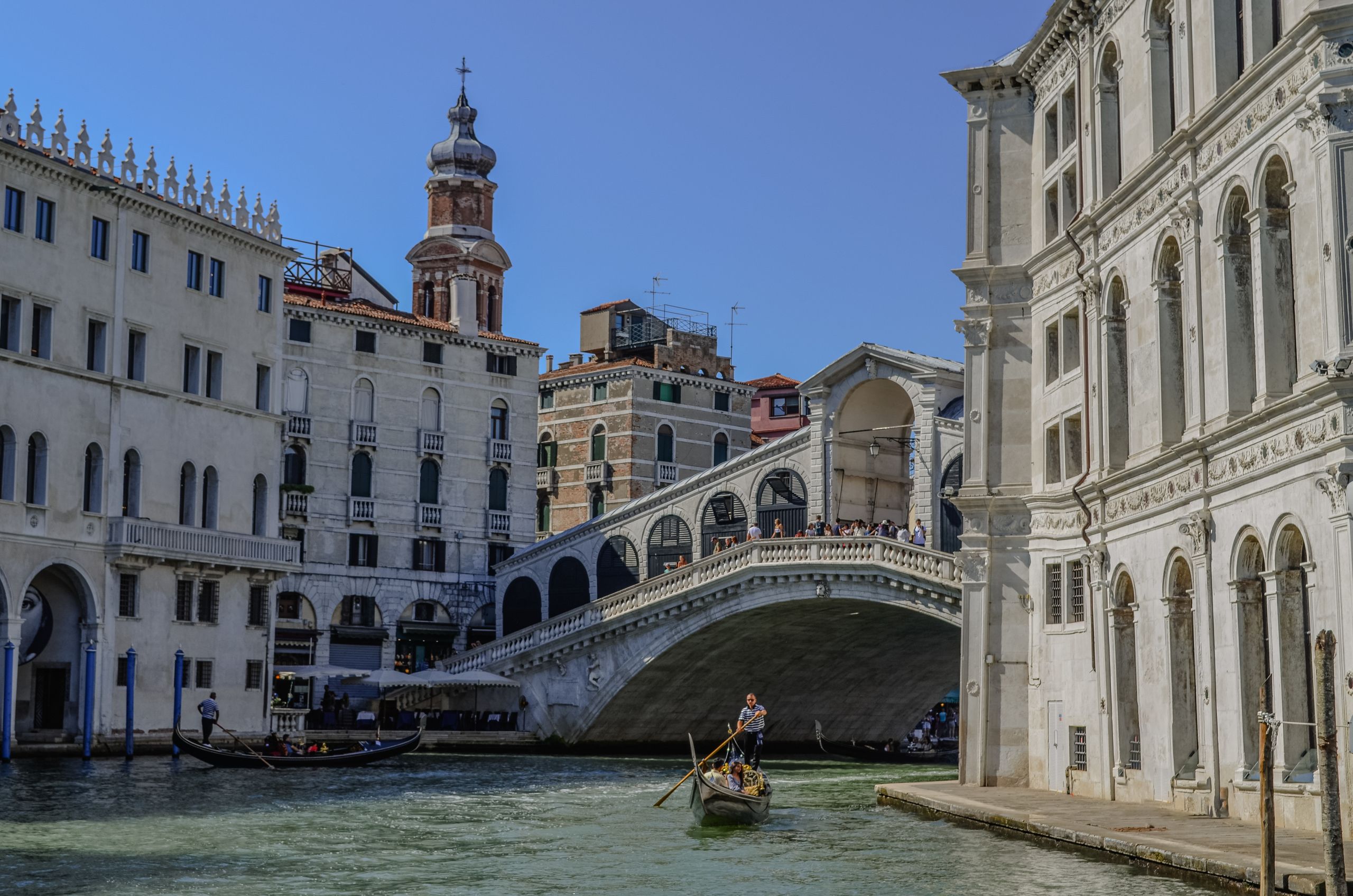Serene view of gondolas near iconic Rialto Bridge in Venice, Italy.